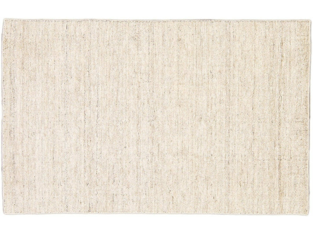 Beautiful Modern Delino hand-loom wool beige field. This piece has a gorgeous all-over solid design.  This rug measures 5' x 8'.