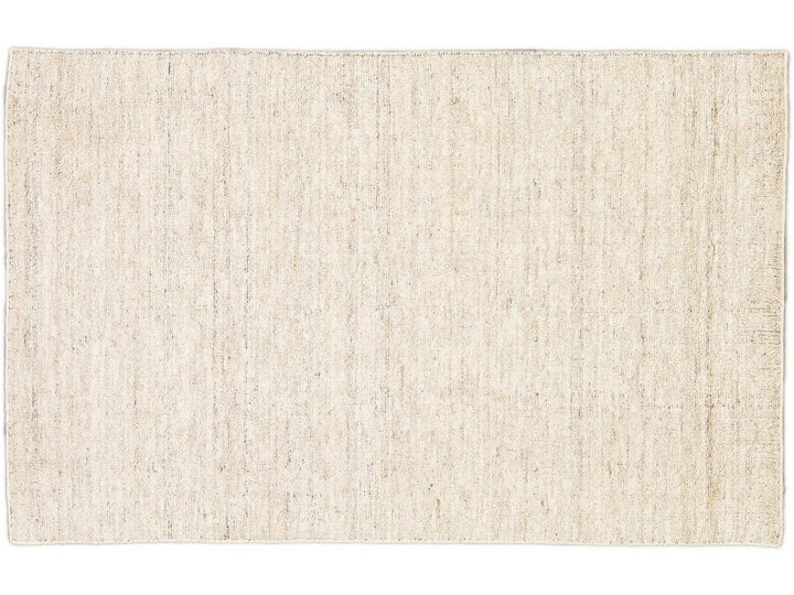 Beautiful Modern Delino hand-loom wool beige field. This piece has a gorgeous all-over solid design.  This rug measures 5' x 8'.