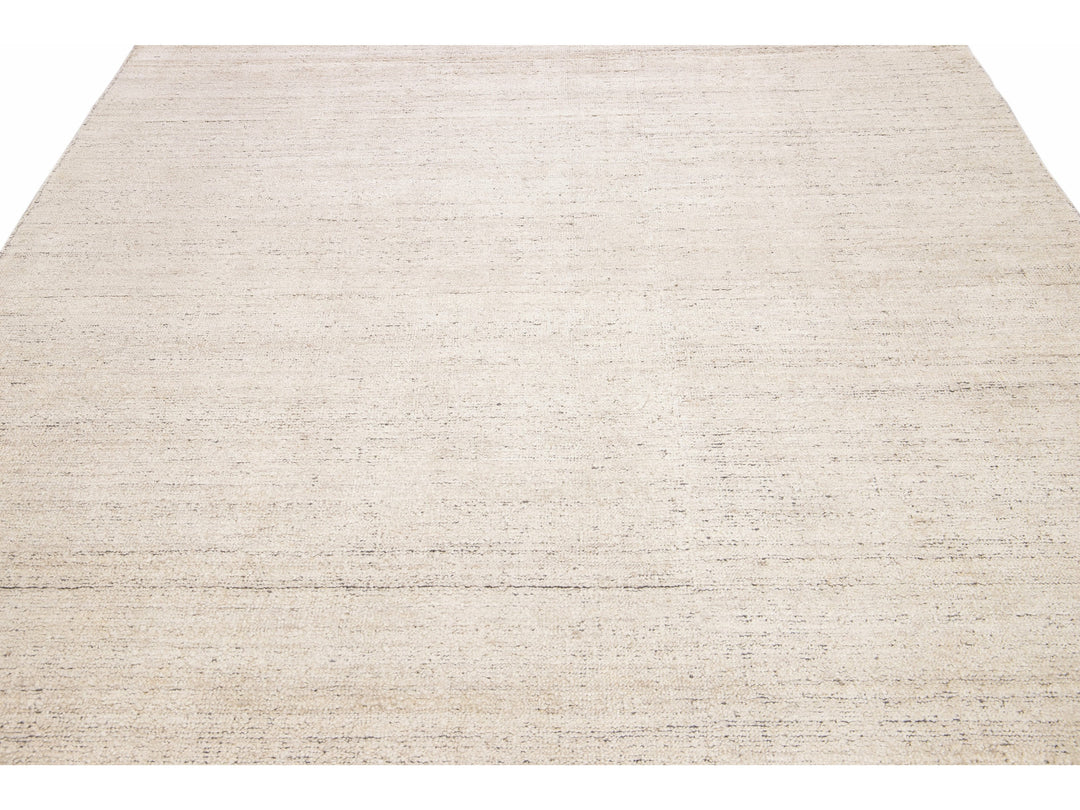 Beautiful Modern Delino hand-loom wool beige field. This piece has a gorgeous all-over solid design.  This rug measures 5' x 8'.