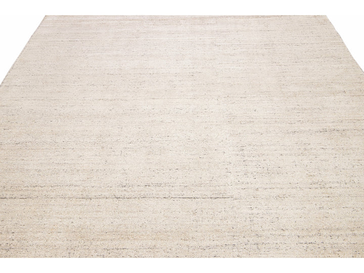 Beautiful Modern Delino hand-loom wool beige field. This piece has a gorgeous all-over solid design.  This rug measures 5' x 8'.