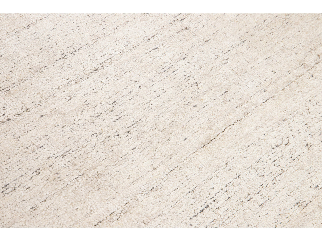 Beautiful Modern Delino hand-loom wool beige field. This piece has a gorgeous all-over solid design.  This rug measures 5' x 8'.