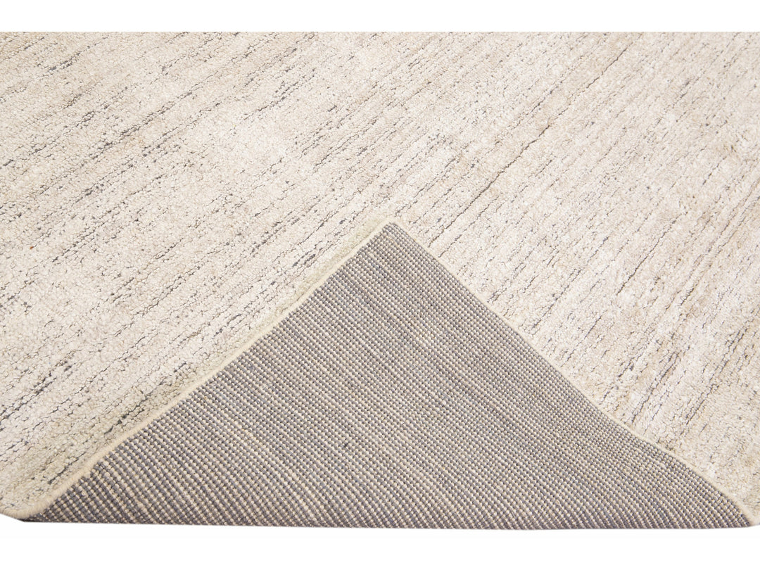 Beautiful Modern Delino hand-loom wool beige field. This piece has a gorgeous all-over solid design.  This rug measures 5' x 8'.