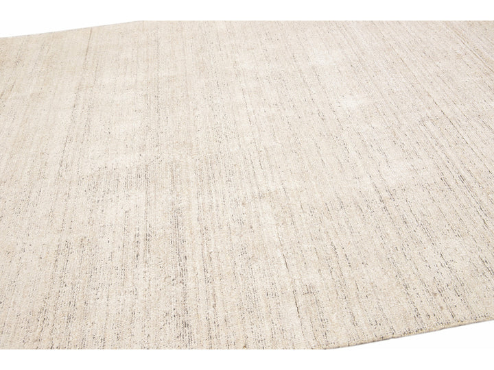 Beautiful Modern Delino hand-loom wool beige field. This piece has a gorgeous all-over solid design.  This rug measures 5' x 8'.