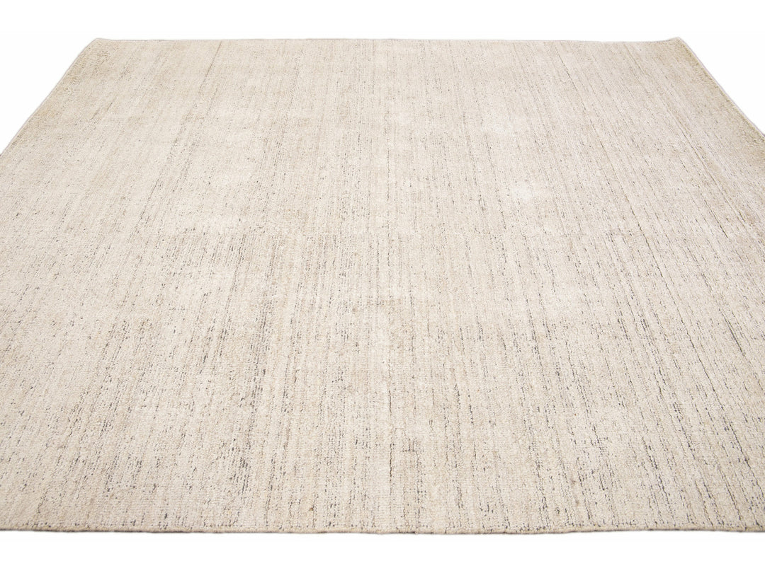 Beautiful Modern Delino hand-loom wool beige field. This piece has a gorgeous all-over solid design.  This rug measures 5' x 8'.