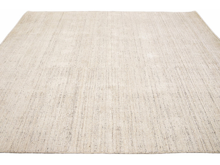Beautiful Modern Delino hand-loom wool beige field. This piece has a gorgeous all-over solid design.  This rug measures 5' x 8'.